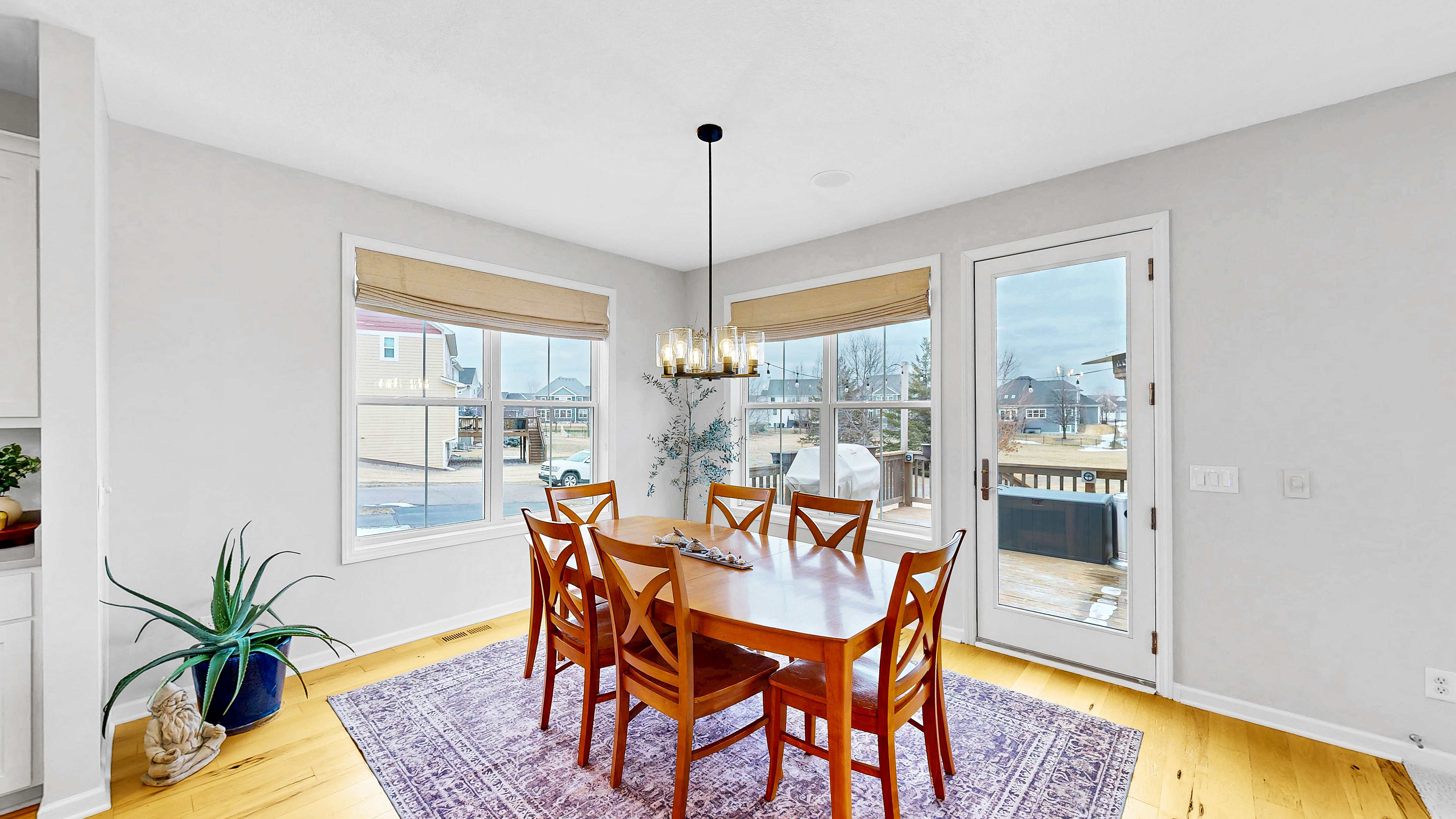 Dining area with bay window, hardwood floors, and patio door to deck