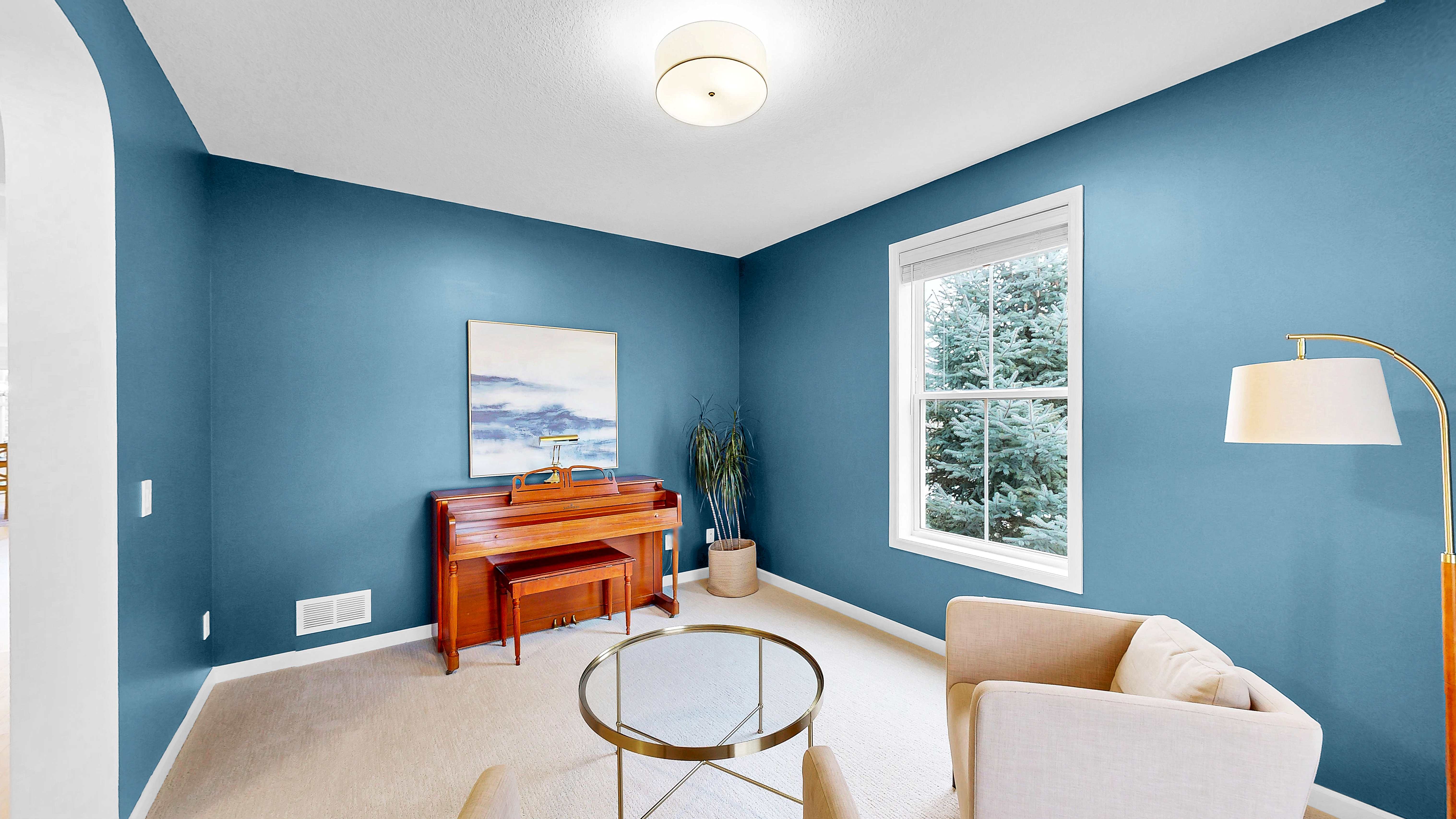 Piano room with blue accent walls and arched doorway