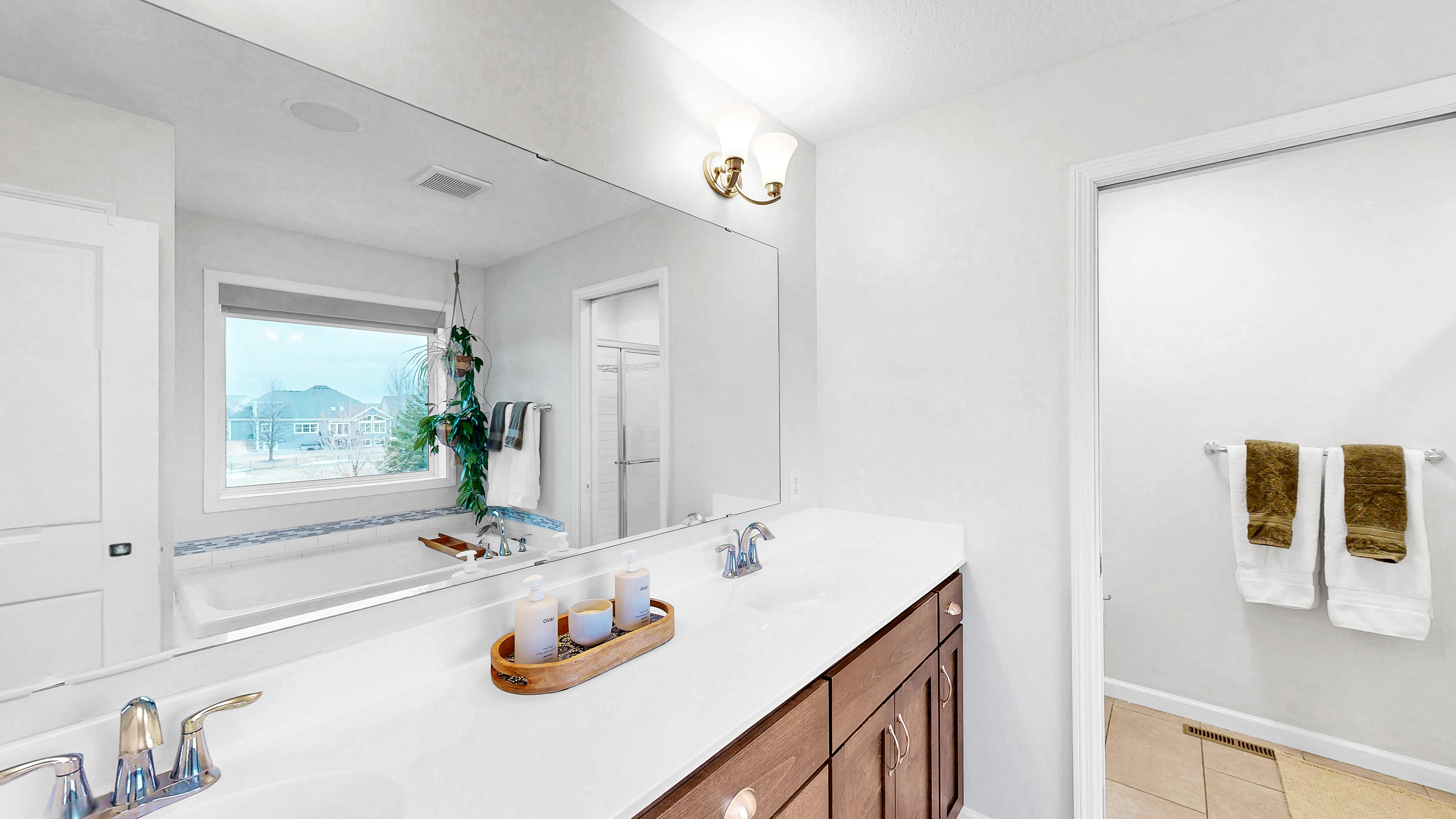 Primary en suite bath with double vanity, soaking tub by window