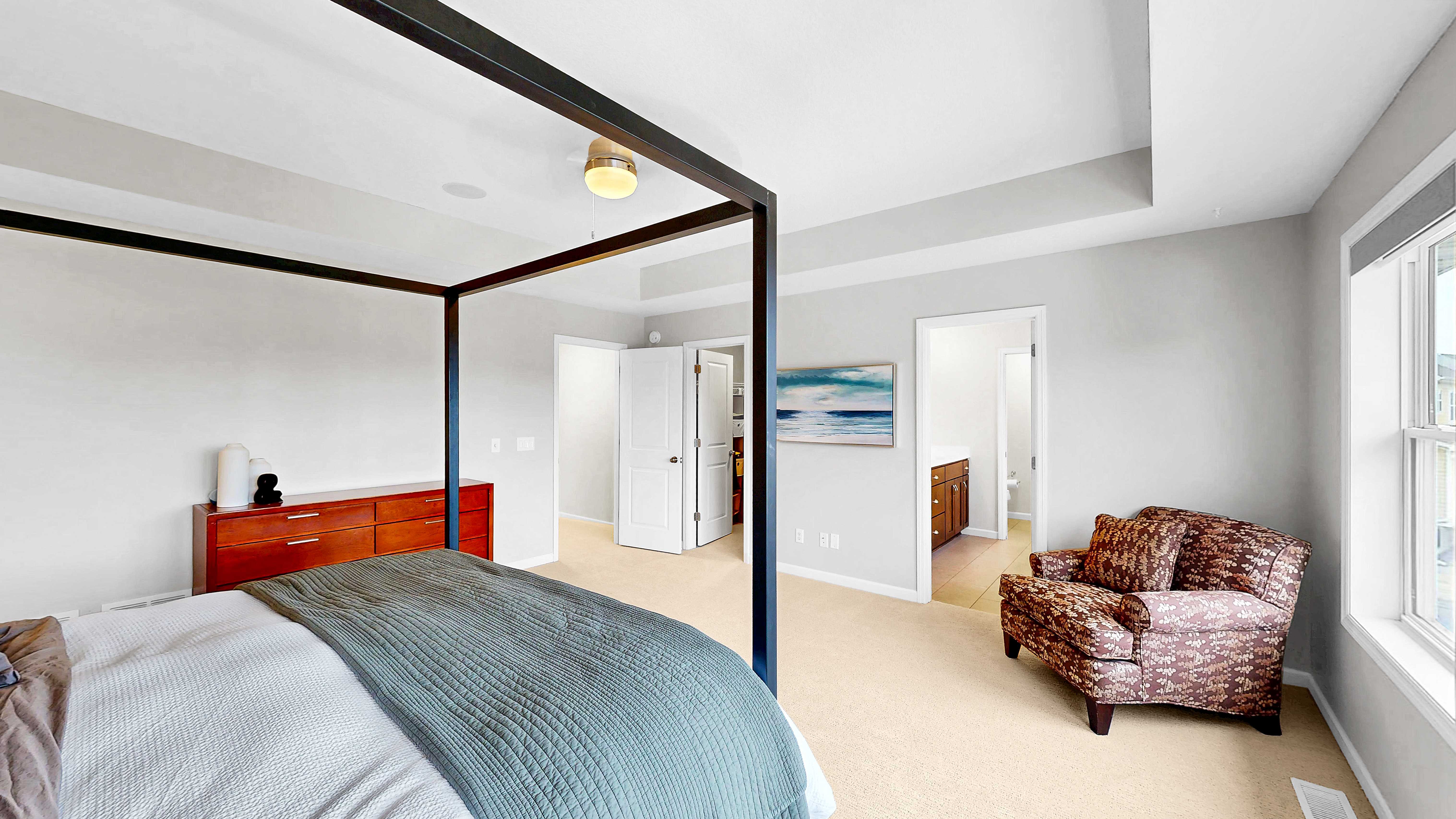 Primary bedroom showing walk-in closet and en suite bath entry